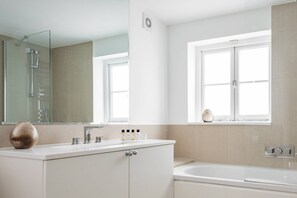 Appartement (3 Bedrooms) | Badkamer | Een bad/douchecombinatie, een haardroger, handdoeken, shampoo