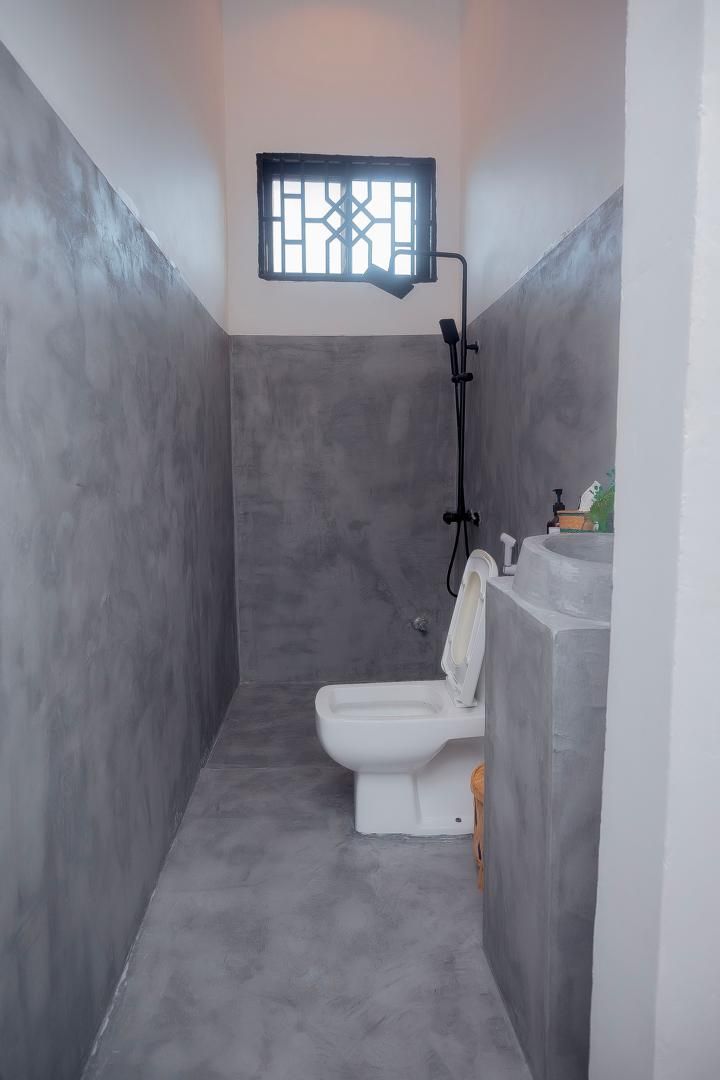 Un baño pequeño con inodoro, ducha y lavamanos.