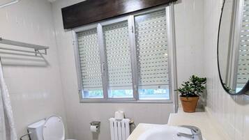 Een douche, handdoeken, zeep, toiletpapier