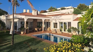 A house with a swimming pool, outdoor furniture, and a garden. - Villa Gecko (La Puntilla)