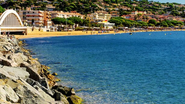 A coastal town with a beach, rocky shoreline, and buildings on a hillside. - BLUE AIR-CONDITIONED STUDIO CABIN SLEEPS 4 (Sainte-Maxime)
