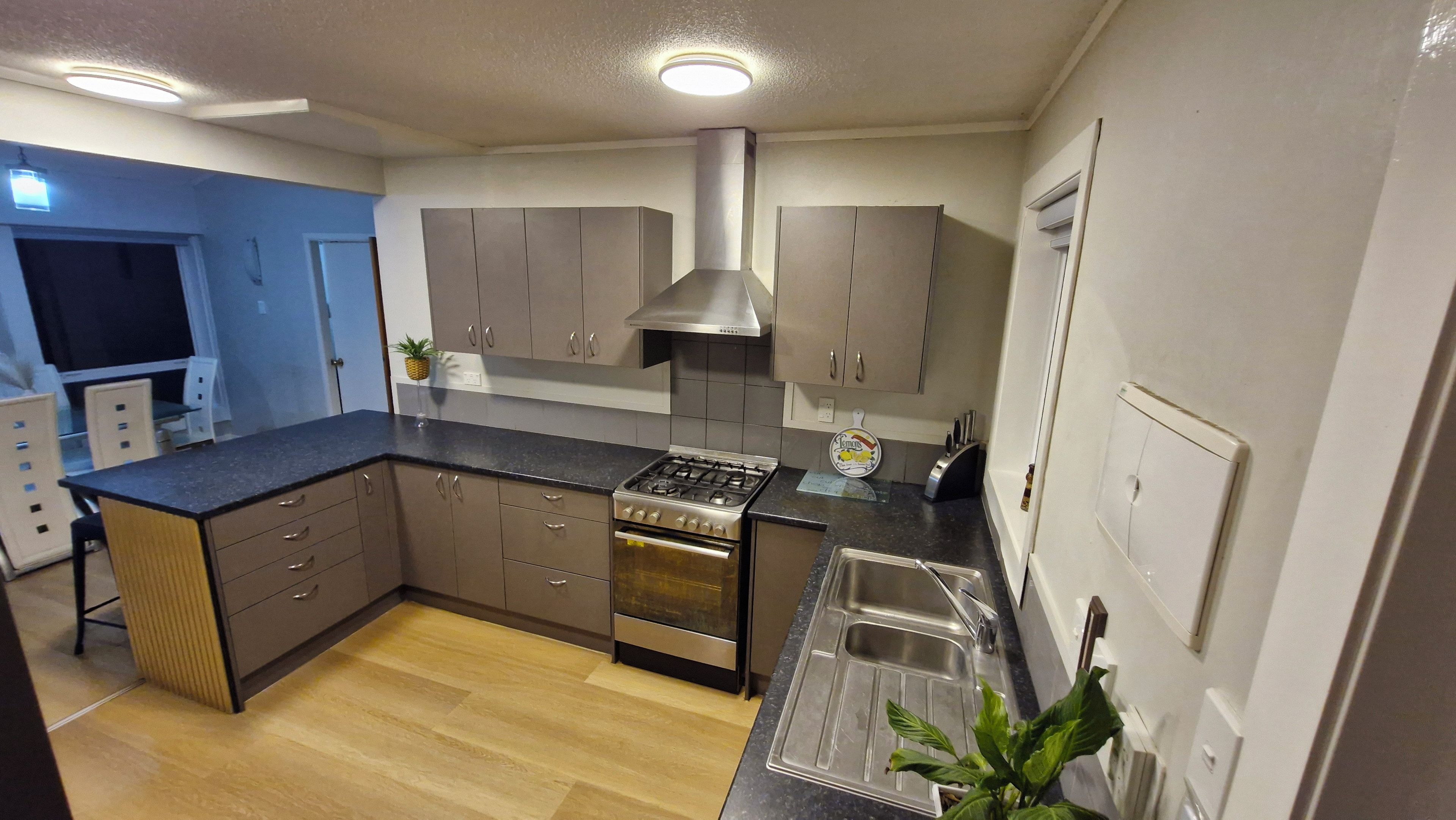 A modern kitchen with a central island, stainless steel appliances, and a built-in oven.