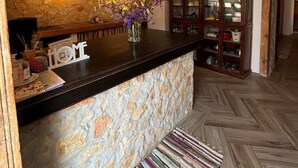 A kitchen with a stone countertop, wooden cabinets, and a herringbone floor pattern.