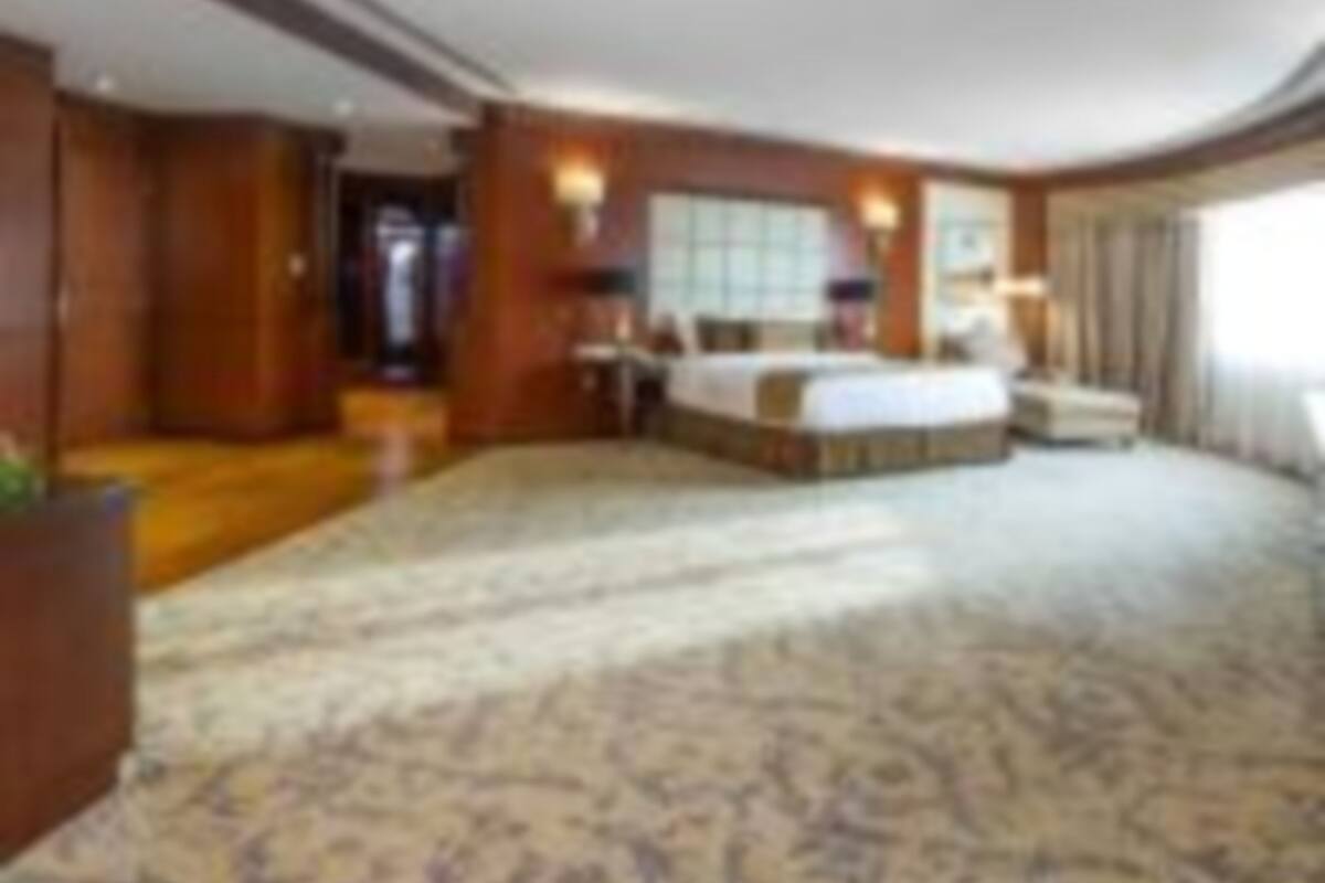 Une chambre d’hôtel avec un grand lit, un bureau et un coin salon.