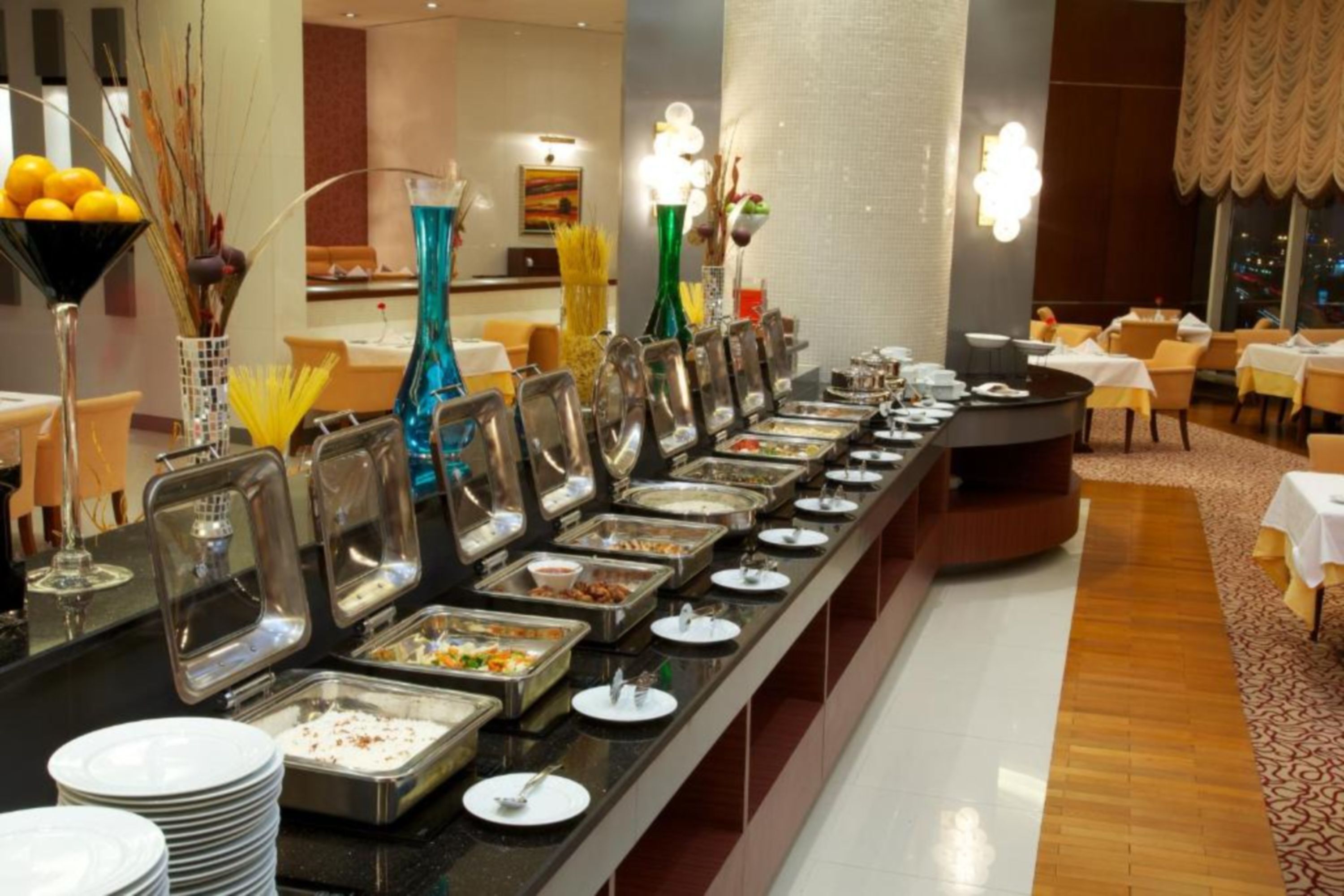 A buffet setup with various food stations, a reception area, and a seating area with tables and chairs.