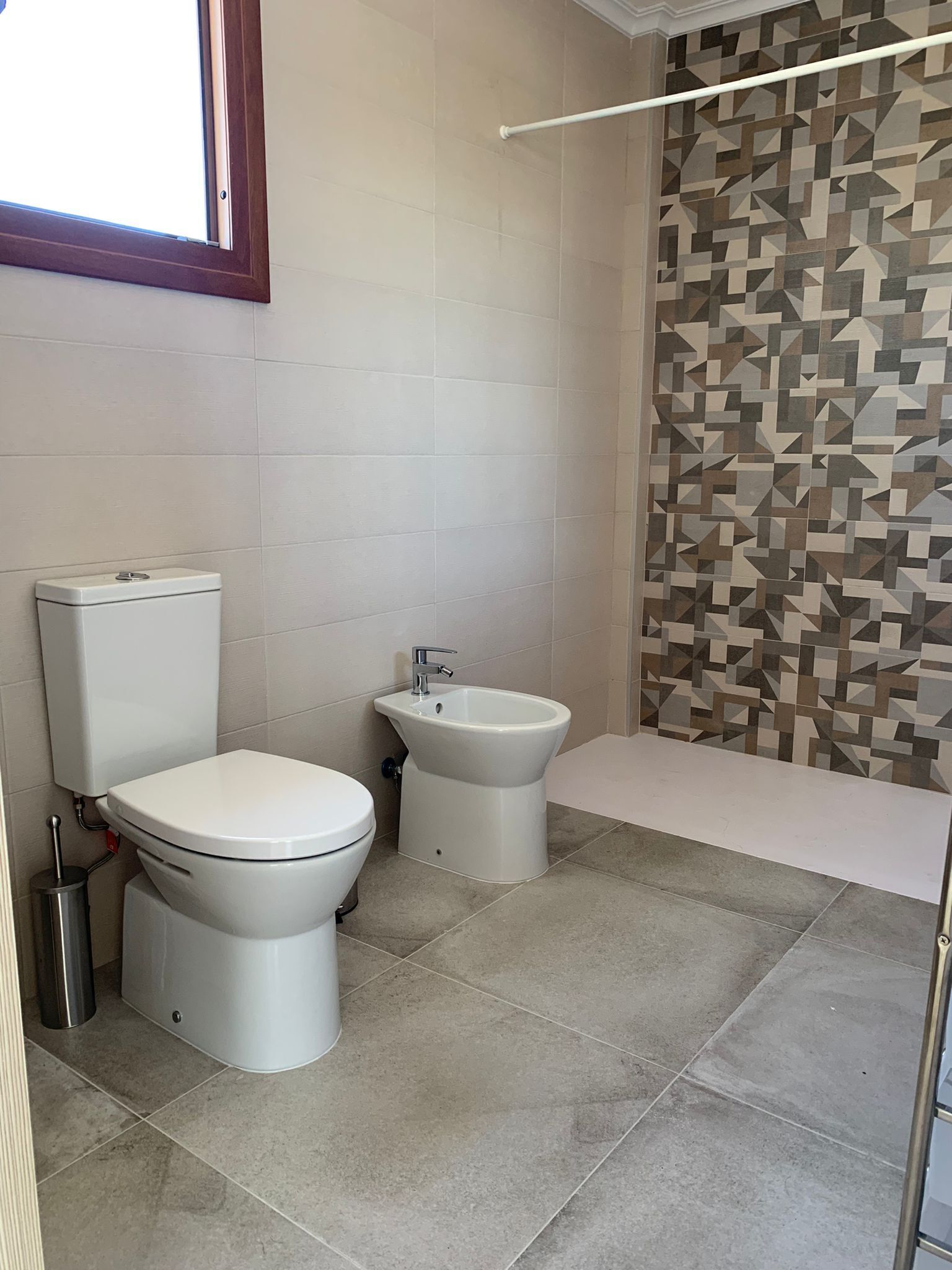A bathroom with a toilet, bidet, and bathtub.