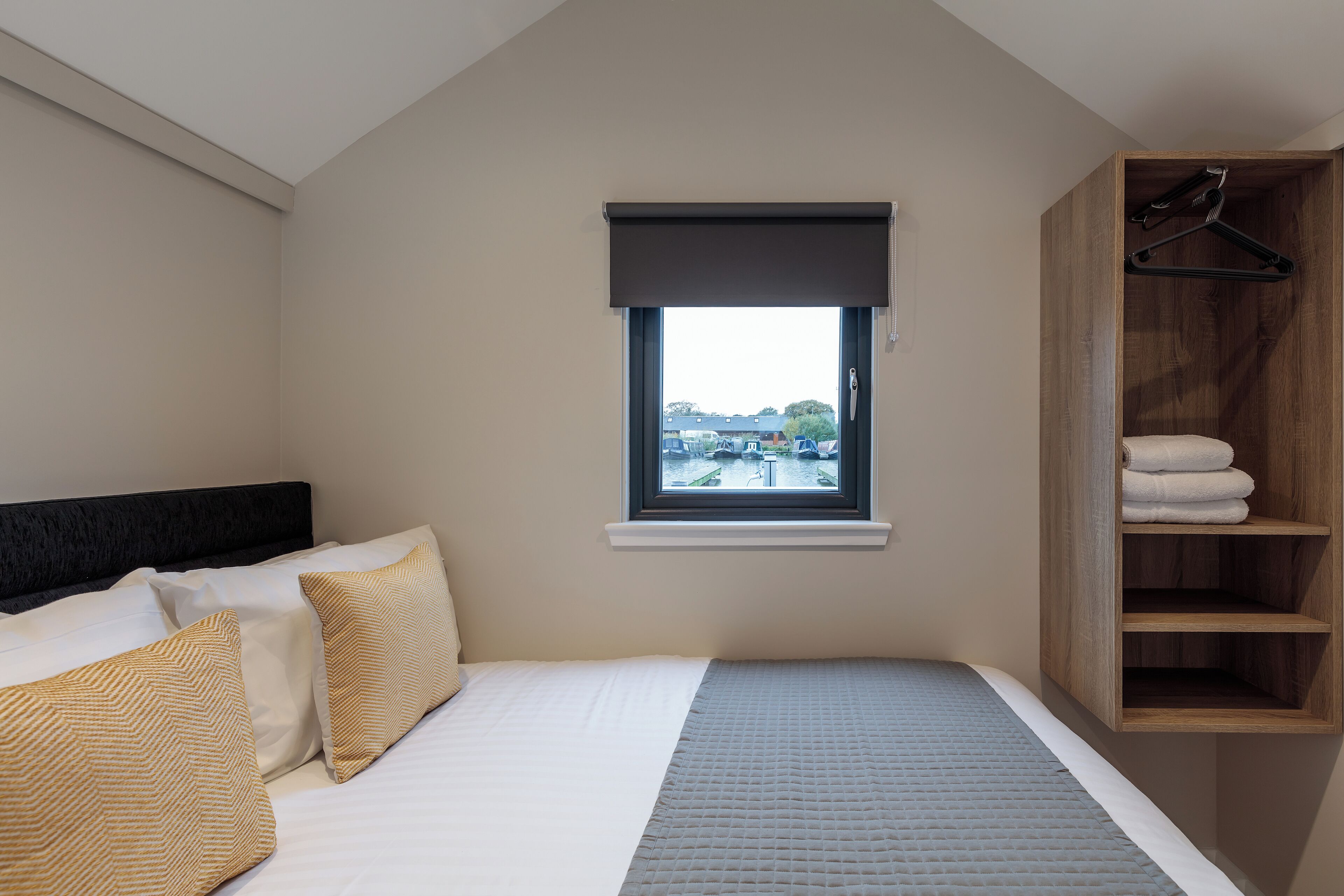 Un dormitorio con cama, ventana con vistas y armario de madera.