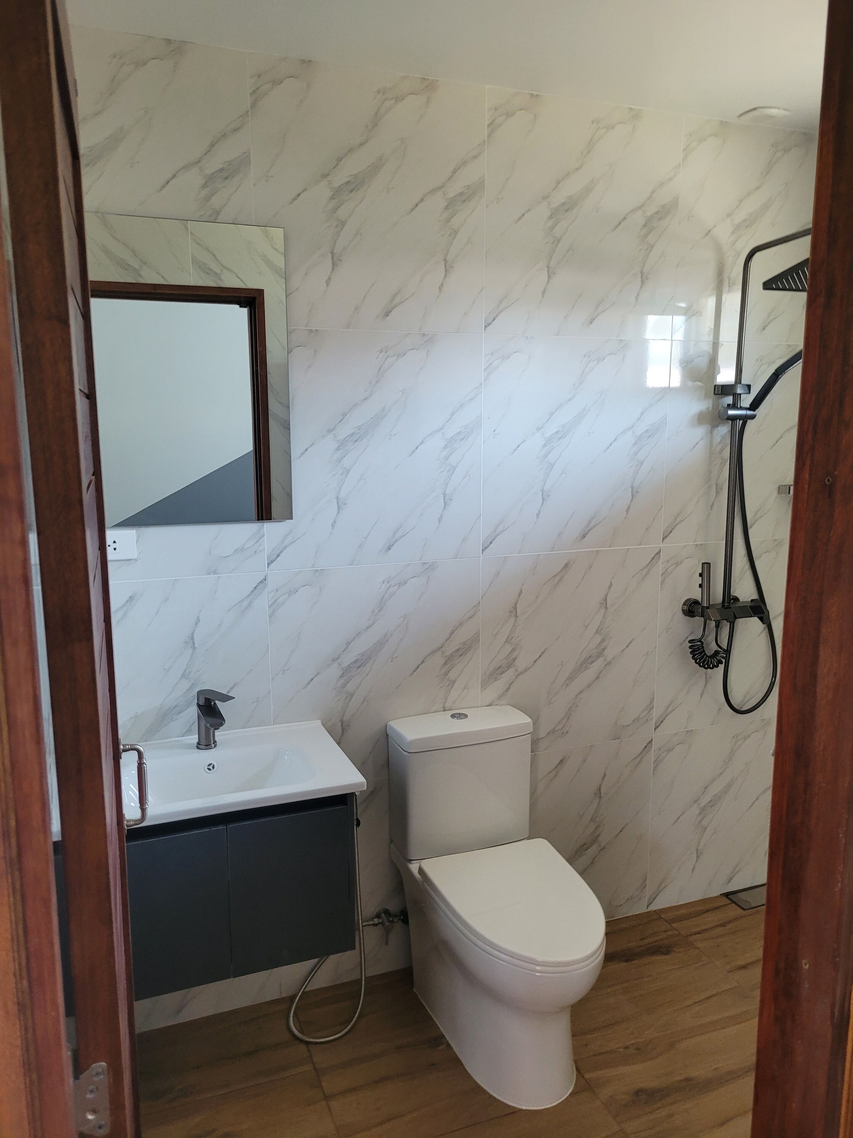A bathroom with a toilet, sink, and shower.