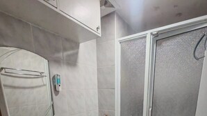 A bathroom with a sink, toilet, and shower.