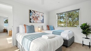 A modern hotel room with two beds, a large window with a view of trees, and a painting on the wall. - Azure House - freedom beckons just 300m from Callala Beach at Jervis Bay (Callala Beach)