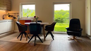 Una cocina moderna con comedor, ventanas amplias y vista a zonas verdes.