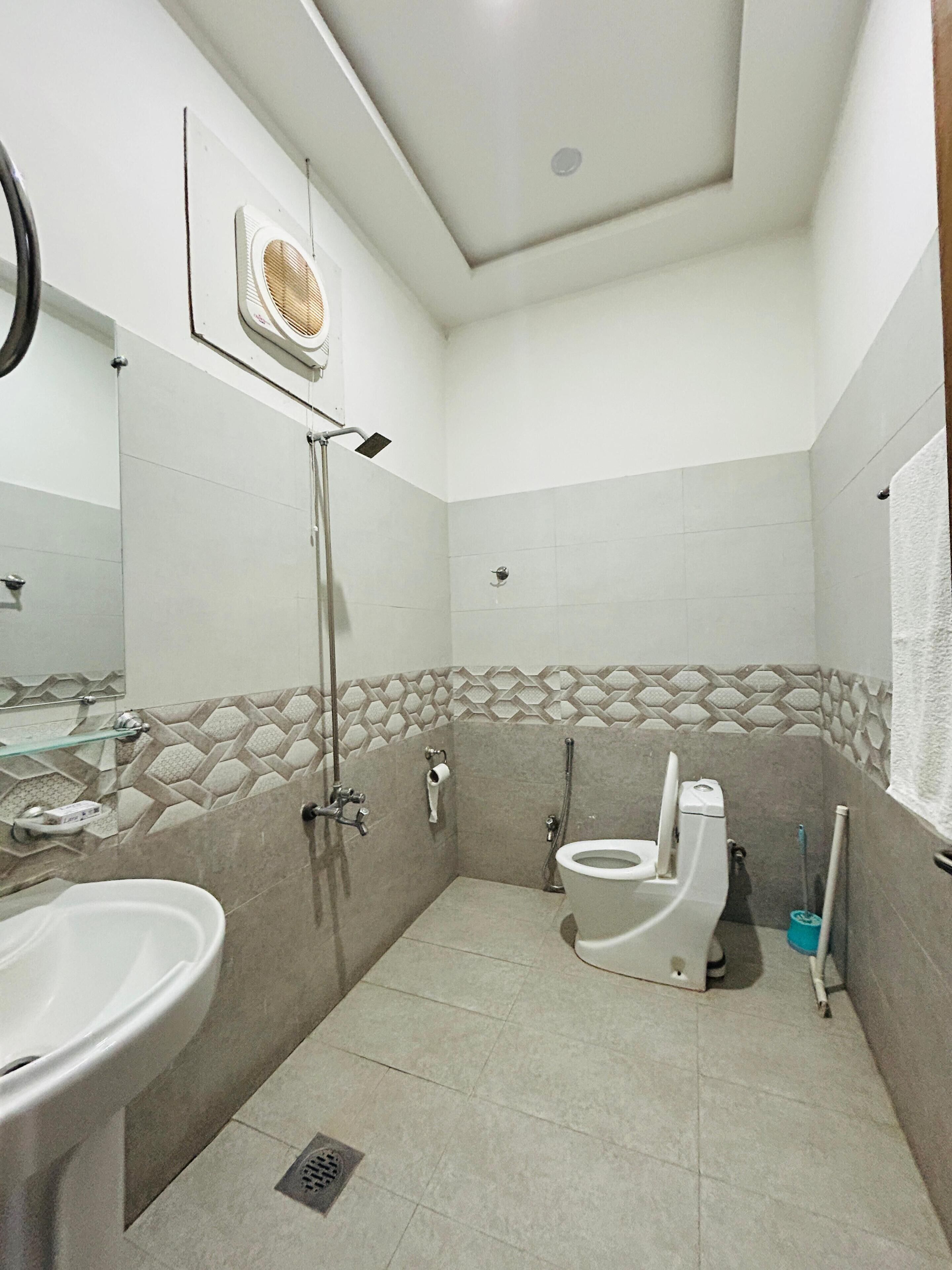 Une salle de bain moderne équipée d’une douche, de toilettes et d’un lavabo.