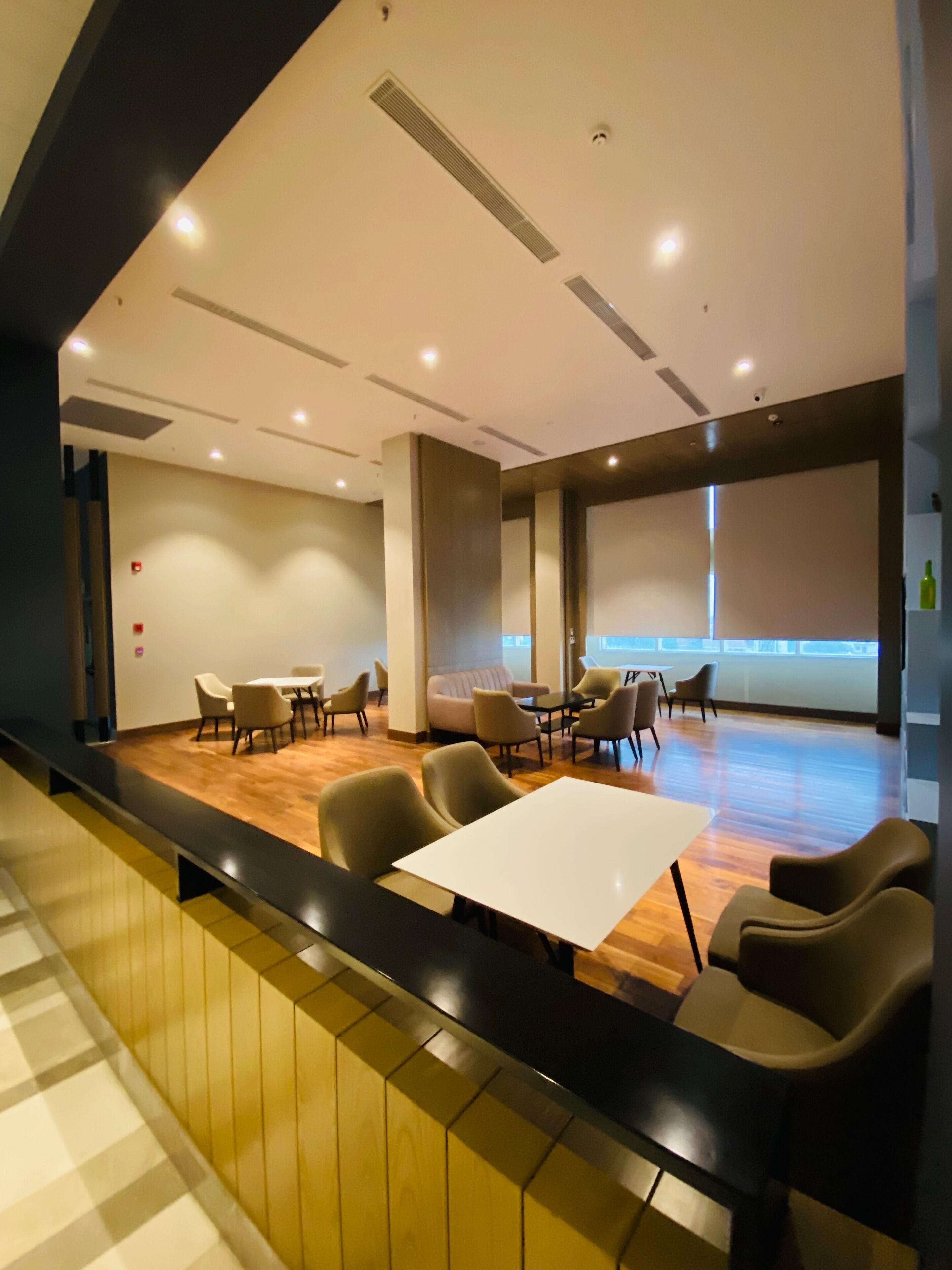A spacious conference room with a long table, several chairs, and a large screen.