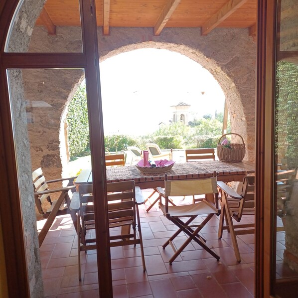 An outdoor dining area with a stone arch, wooden tables, and chairs. - Dolce Vita- x8 Luxury Garda Lake (Gardone Riviera)