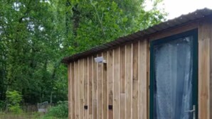 A wooden shed with a green door and a small step leading up to it. - Dodôme étoilé-Love Room (Saint-Germain-d'Esteuil)