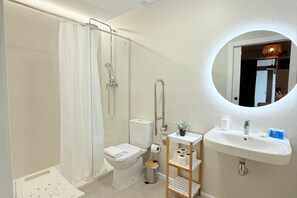 Un bagno moderno dotato di doccia, WC, lavandino e specchio.
