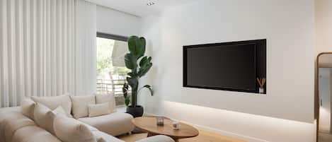 A modern living room with a beige sofa, a coffee table, a large potted plant, and a mounted TV on the wall.