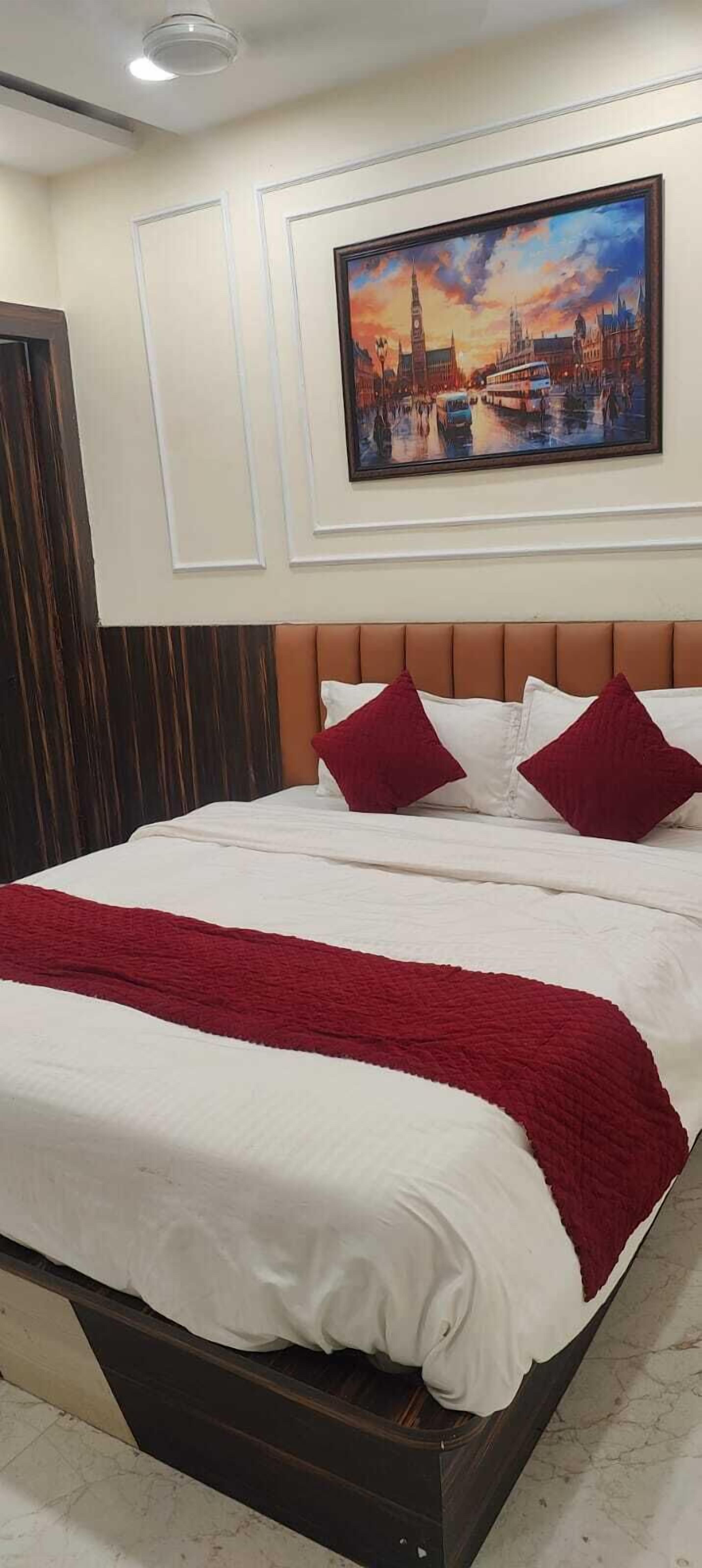 Habitación de hotel con una cama grande, un cuadro de paisaje urbano en la pared y un cabecero de madera.
