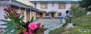 A building with a traditional architectural style, featuring a courtyard and a bicycle parked outside. - Punatsangchhu Cottages (Wangdue Phodrang)