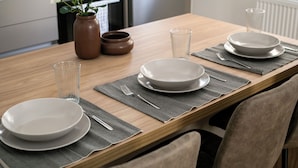 A dining table set with plates, glasses, and cutlery, with a vase of flowers and a pot on the side. - Anatoli - Athenian 2-BR Apartment in Athens (Zografos)