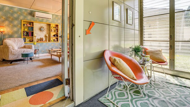 A cozy living room with a sofa, chairs, and a bookshelf. - Lustron of the Lakes: Retro MCM Gem in Tangletown (Minneapolis)