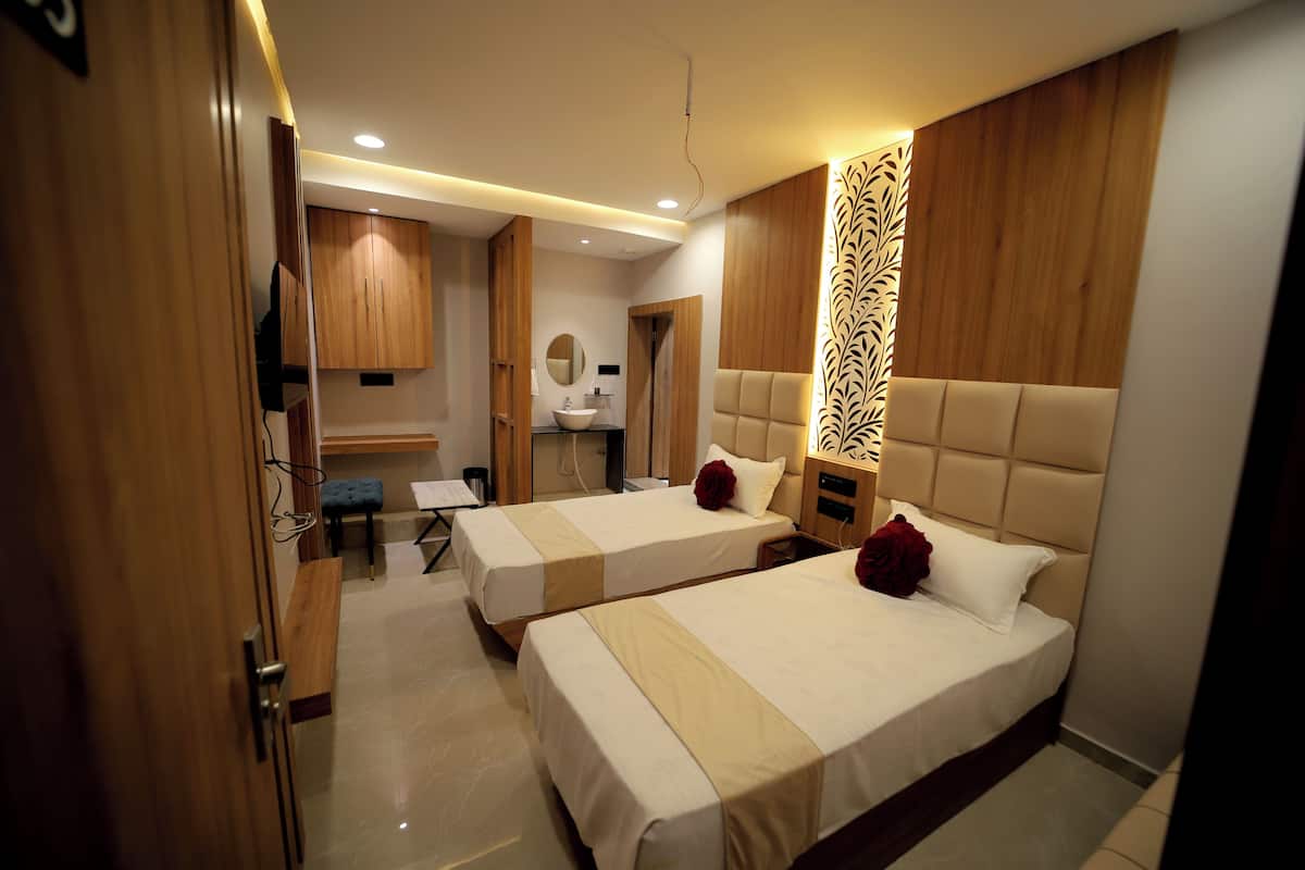 Una habitación de hotel con dos camas, un baño y un escritorio.