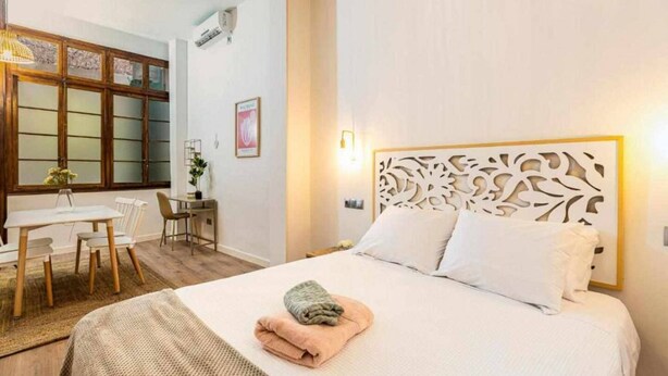 A hotel room with a bed, a desk, and a chair.