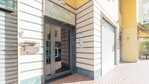 A building entrance with a sign reading "Palazzo La Madonnina" and a mailbox.