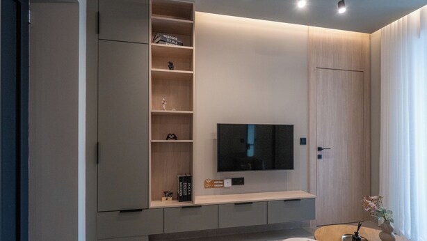 A modern living room with a built-in TV, wooden shelving, and a minimalist design. - Latitude 37 (Kalamata)