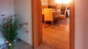 An interior hallway with a wooden door leading to a dining area. - Apartments Jukic (Sveti Filip i Jakov)