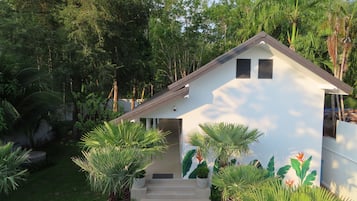 A modern house with a white exterior, a sloped roof, and a front entrance with steps.