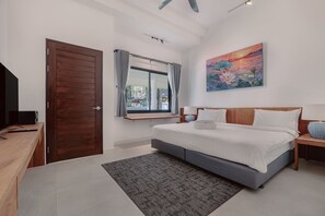 Ein Schlafzimmer mit Bett, Schreibtisch, Fernseher, einem Fenster mit Vorhängen und einem Bild an der Wand.