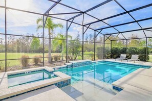 A swimming pool with a glass enclosure, surrounded by a landscaped garden and palm trees. - Upstay 32 Guest Mansion - Pool, Hot Tub, Games (Kissimmee)