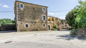 An old stone building with a courtyard, a gate, and a small balcony. - Room 'Sajolida' with Shared Pool, Wi-Fi and Air Conditioning (Borrassà)