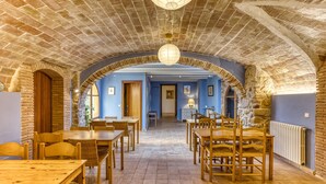 Ein Restaurant mit Backsteinbögen, Holztischen und blauem Interieur.