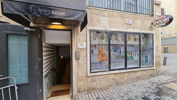 A hotel entrance with a glass facade displaying artwork. - SpaceART (Jerusalem)