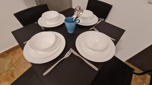 A dining table set with white plates, a blue mug, and silverware. - SpaceART (Jerusalem)