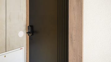 Une porte portant le numéro « 5 », une poignée de porte et une petite fenêtre circulaire située sur le côté gauche.