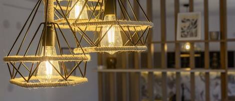 Un interior moderno con lámparas geométricas y un separador de madera.