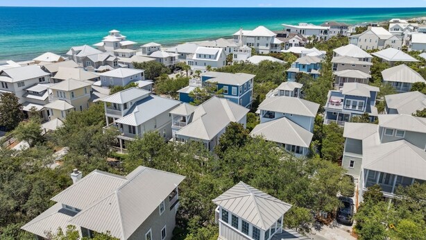 A coastal residential area with houses featuring gabled roofs and a view of the ocean.
