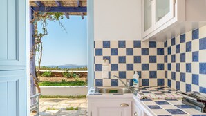 A kitchen with a checkered tile backsplash, a sink, and a view of the outdoors. - Apartment '7' with sea view, Wi-Fi and air conditioning (Tinos)