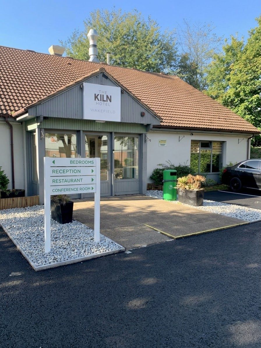 A hotel named 'The Kiln Hotel' with a sign indicating the location of bedrooms, reception, restaurant, and conference room.