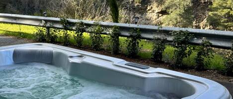 A hot tub with a view of a mountainous landscape.