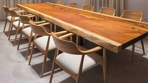 Une salle de conférence dotée d’une longue table en bois, de six chaises et d’un haut plafond en bois avec des poutres apparentes et un éclairage encastré.