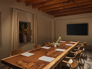 A conference room with a long wooden table, chairs, papers, and a window with curtains. - Pine View Boutique Hotel Adults Only (Saittas)