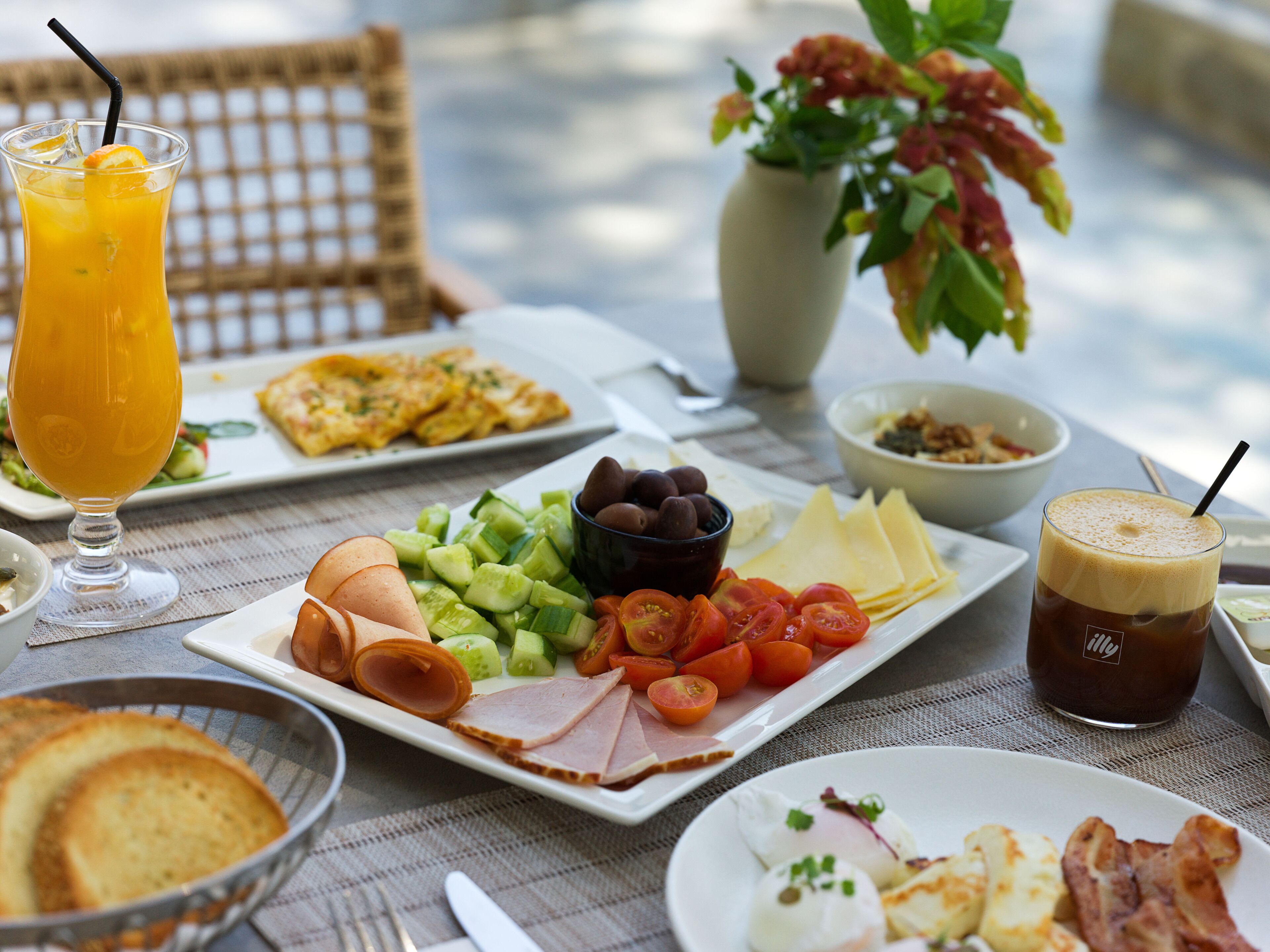 A breakfast setting with various food items and drinks on a table.
