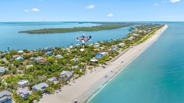 An aerial view of a coastal resort with beachfront properties, a marina, and a clear blue sky. - Ventura Captiva 2b 3 Bedroom Condo (Captiva)