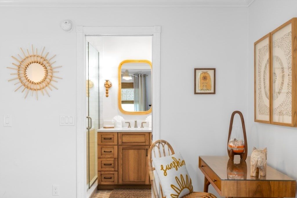 A bathroom with a vanity, mirror, and decorative items.
