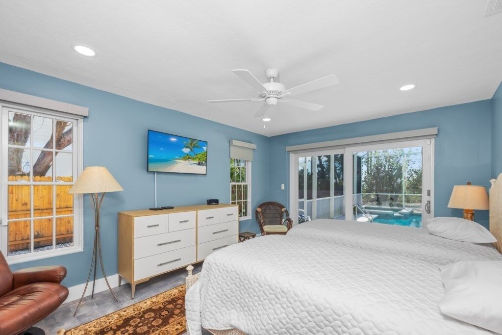 A bedroom with a bed, a chair, a dresser, a lamp, and a painting on the wall.