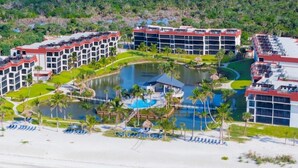 A resort with multiple buildings, a central pool, and a beach area. - Pointe Santo D27 2 Bedroom Condo (Sanibel)